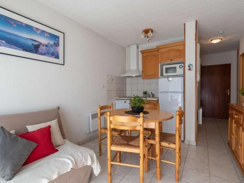 - une cuisine et une salle à manger avec une table et un canapé dans l'établissement Appartement confortable 4 pers, Saint-Lary, proche pistes et commodités - FR-1-296-212, à Saint-Lary-Soulan