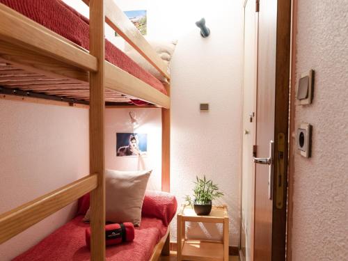 Cette chambre comprend des lits superposés et un canapé rouge. dans l'établissement Appartement calme proche centre, parking et balcon, Saint-Lary - FR-1-296-194, à Saint-Lary-Soulan