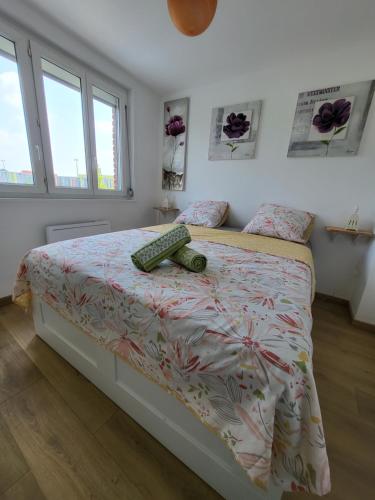 a bedroom with a bed with a comforter on it at Maison THEB in Saint-André-lez-Lille