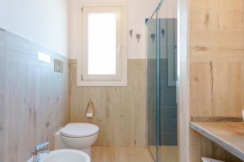 a bathroom with a toilet and a glass shower at Domo Green House in Villasimius