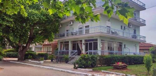 a large white building with a balcony on it at Ermis in Loutra Ipatis