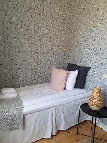 a bed in a room with a wall covered in wallpaper at STF Gysinge Wärdshus & Hotell in Gysinge