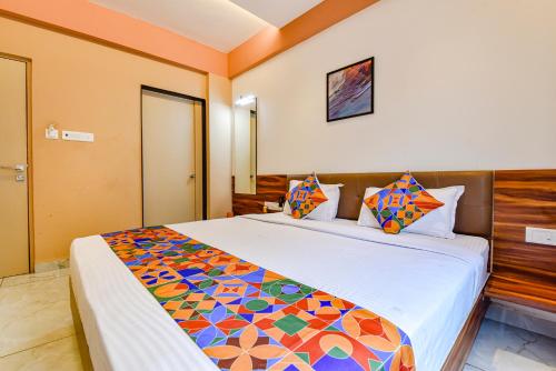 a bedroom with a large bed with a colorful comforter at FabHotel Peak Stay in Porvorim