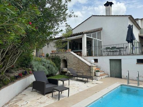 a house with a swimming pool in front of a house at Zak Experience in Générac