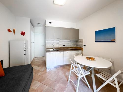 a kitchen with a white table and a white refrigerator at Appartamento Stefania Località Nisportino in Rio nellʼElba