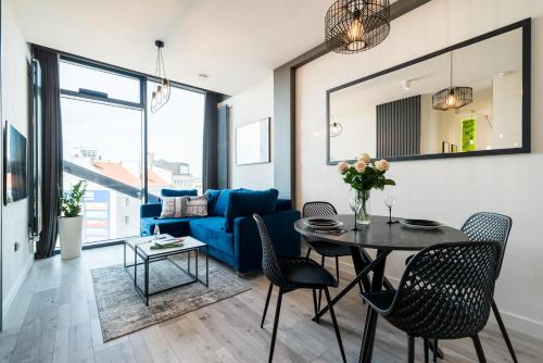 a living room with a table and chairs and a blue couch at Q18 ApartHotel in Bydgoszcz