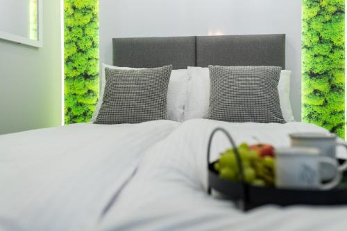 a white bed with a tray of fruit on it at Q18 ApartHotel in Bydgoszcz