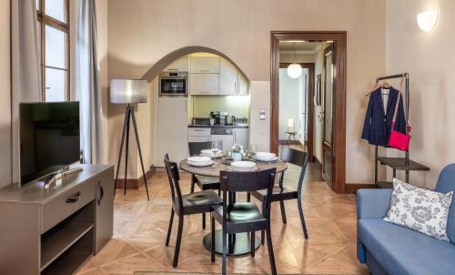 a living room with a table and a blue couch at 3 Epoques Apartments by Adrez in Prague