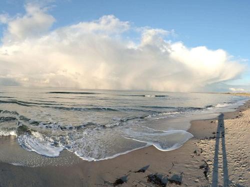 a beach with the ocean and a cloudy sky at with a view of the Bodden in Ribnitz-Damgarten