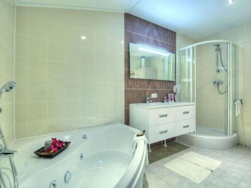 a bathroom with a tub and a shower and a sink at Mobile home "Romantic Suite" M 160 in Fehmarn