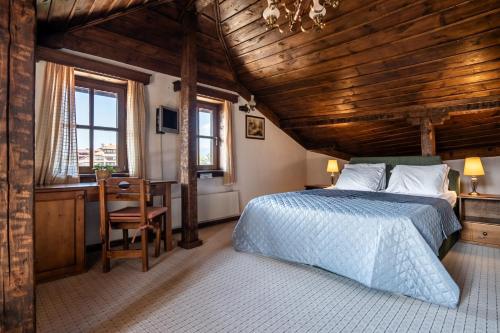 1 dormitorio con 1 cama, escritorio y ventanas en Chalet White Fang, en Bansko