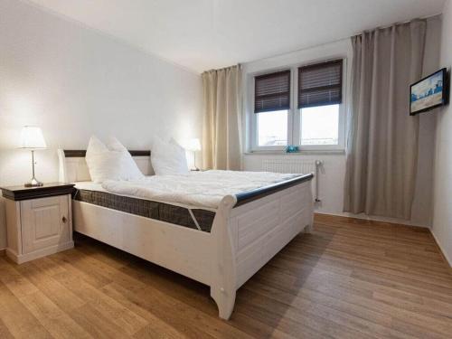 a bedroom with a large white bed in a room at Strandeck Zuidstrand in Göhren