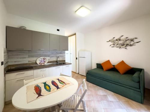 a living room with a white table and a green couch at Appartamento Stefania Località Nisportino in Rio nellʼElba