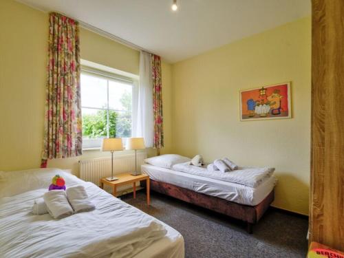a hotel room with two beds and a window at By the golf course in Wulfen on Fehmarn in Fehmarn