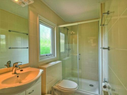 a bathroom with a sink and a toilet and a shower at - The "Ocala" mobile home in Fehmarn