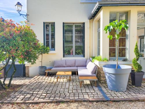 a purple couch on a patio in front of a house at Domaine Le Clos de la Source - Spa - Petit déjeuner buffet - Atelier d'art in Montrichard