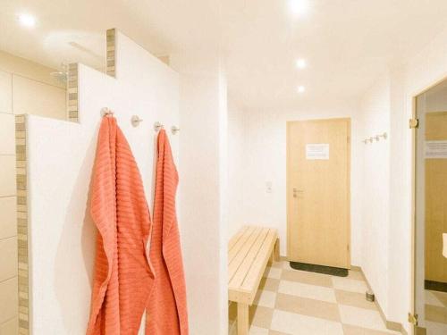 a bathroom with orange towels hanging on a wall at Nordzeeoase-Pethan met sauna in Neuharlingersiel