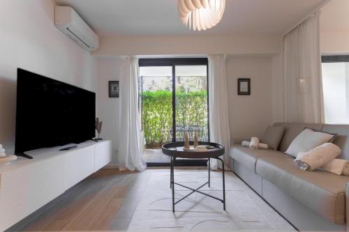 un salon avec un canapé, une télévision et une table dans l'établissement LE MAJORELLE appartement de design avec externe, à Cannes