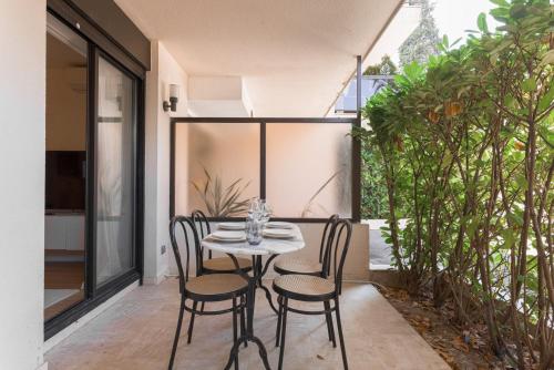 une table et des chaises sur le patio d'une maison dans l'établissement LE MAJORELLE appartement de design avec externe, à Cannes