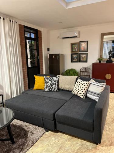 a couch in a living room with pillows on it at Kallista Villa Kalibaru in Kalibaru