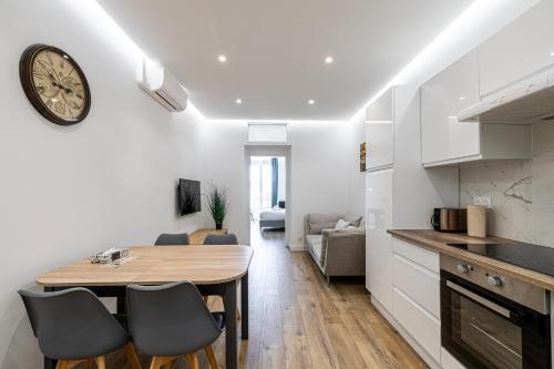 une cuisine et une salle à manger avec une horloge murale dans l'établissement LE BAMBOO idéalement situé en centre-ville, pour familles ou petits groupes, à Cannes