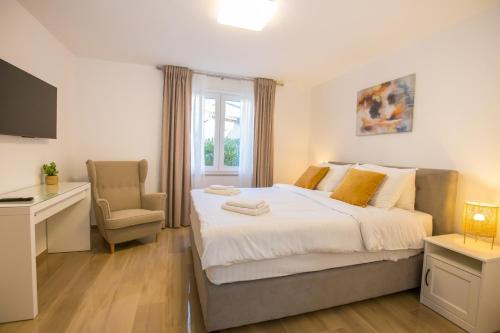 a bedroom with a bed and a desk and a chair at Apartment Riva Parenzo in Poreč