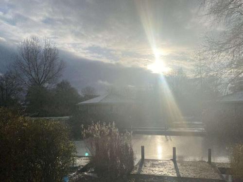 a misty sunrise over a pond with the sun shining at Sunhouse Makkum Beach in Makkum