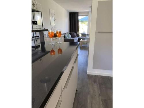 a kitchen with a counter with orange vases on it at Sunhouse Makkum Beach in Makkum