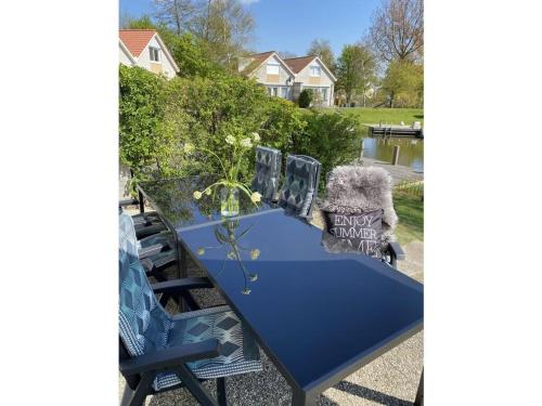 a blue table with chairs and flowers on it at Sunhouse Makkum Beach in Makkum