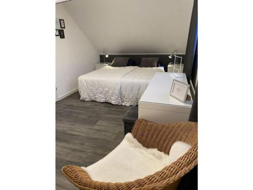 a bedroom with a bed and a chair in it at Sunhouse Makkum Beach in Makkum