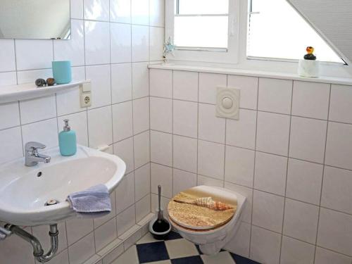 a bathroom with a sink and a toilet and a window at House in Legde "East" in Norderney