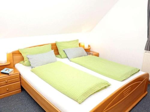 a bedroom with two beds with green and white pillows at House in Legde "East" in Norderney