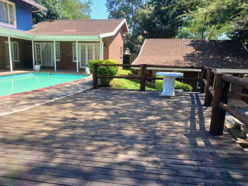 um pátio com uma cerca e uma mesa ao lado de uma casa em Comrades Oasis Guest House em Pietermaritzburg