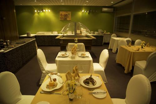 a dining room with white tables and white chairs at Heden Golf Hotel in Abidjan