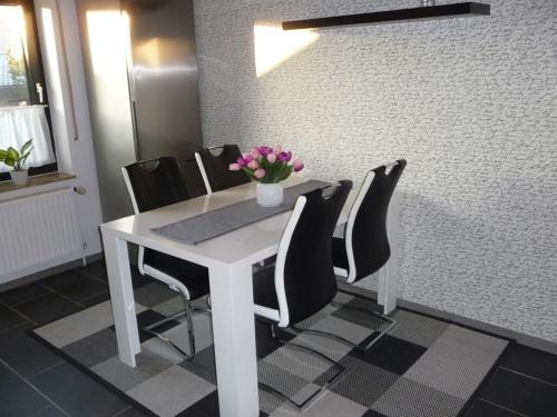 a white table with black chairs and flowers on it at Holiday apartment Bodenwerder in Bodenwerder