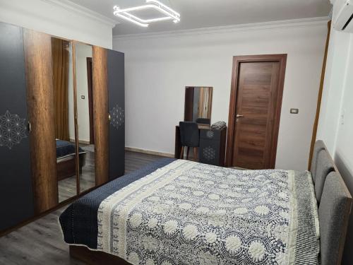 a bedroom with a bed and a mirror in it at El-Shaikh Zayed, 6 october 3BHK flat- families only in Sheikh Zayed