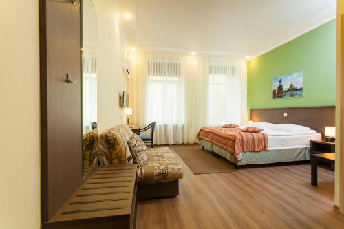 Classiky Mini Hotel في سانت بطرسبرغ: غرفة نوم بسرير واريكة في غرفة