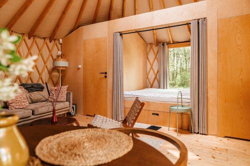 a room with a room with a bed and a table at Dacza Puchacza Glamping in Stare Osieczno