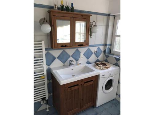 a bathroom with a sink and a washing machine at Haus Butje Comfortable holiday residence in Fedderwarderdeich