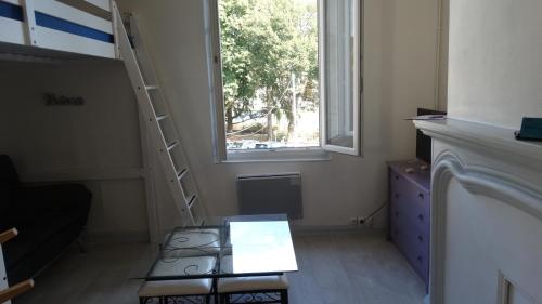 une chambre avec une échelle à côté d'une fenêtre dans l'établissement STUDIOS, à Bergerac