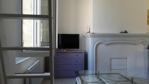 Cette chambre dispose d'une télévision sur une commode et d'un miroir. dans l'établissement STUDIOS, à Bergerac