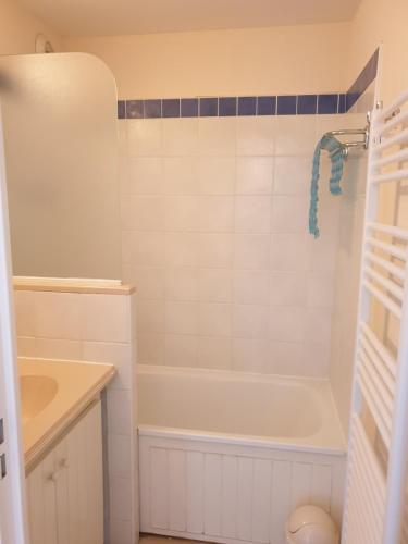 une salle de bain blanche avec une baignoire et un lavabo dans l'établissement Lacanau ocean piscine et océan, à Lacanau-Océan