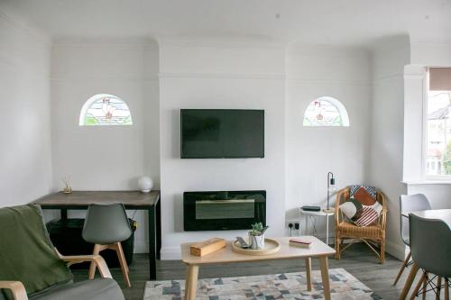 ein Wohnzimmer mit einem TV und einem Kamin in der Unterkunft Stylish Retreat in Leigh-on-Sea in Southend-on-Sea