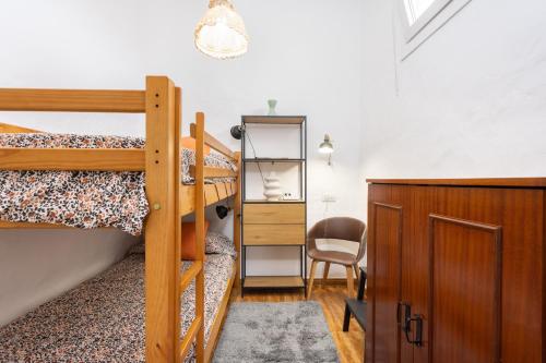 a bedroom with two bunk beds and a chair at OkStay Las Teresitas Tenerife Casa cueva in Güimar