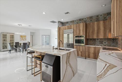a kitchen with wooden cabinets and a counter top at Luxury Modern Waterfront House in BEST Location! King Bed Suite & Close to Beach in West Palm Beach