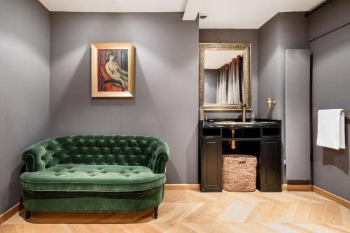 un canapé vert dans une salle de bain avec un miroir dans l'établissement Magnificent Loft Apartment in the Latin Quarter, à Paris