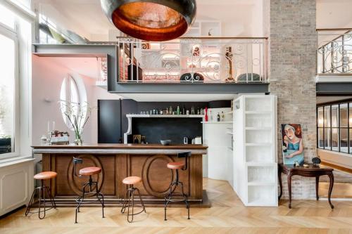 une cuisine avec un bar et des tabourets dans l'établissement Magnificent Loft Apartment in the Latin Quarter, à Paris