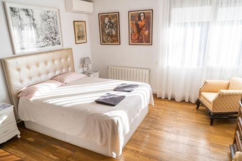 1 dormitorio con 1 cama blanca grande y 1 silla en Villa Radiante 10 de la playa en Sant Vicenç de Montalt