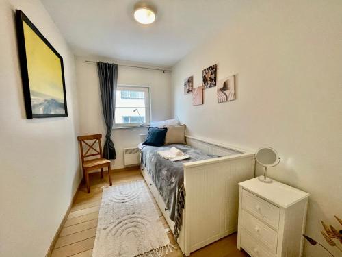 a small bedroom with a bed and a window at 3BR Zeedijk apartment Ocean View in Blankenberge