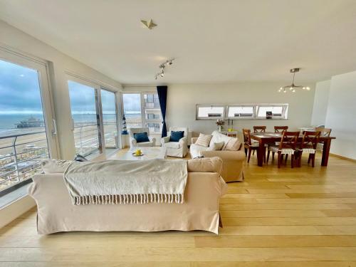 a living room with a couch and a dining room at 3BR Zeedijk apartment Ocean View in Blankenberge